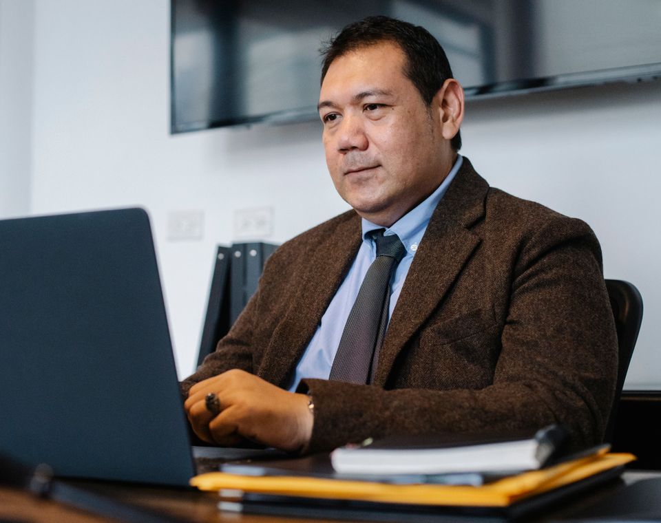 Abogado titular del despacho revisando un expediente en su computadora.